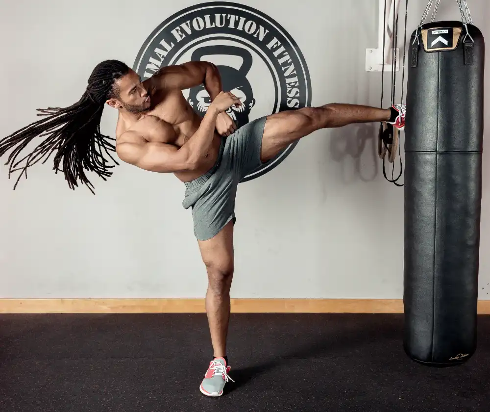 A vibrant of Dubai Personal Trainer, Kicking punching bag.
