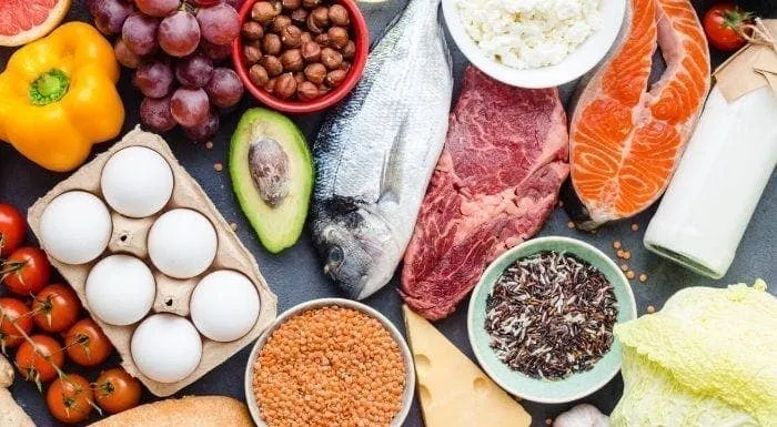 Assortment of protein-rich foods including fish, steak, and eggs to support natural ways to increase testosterone.