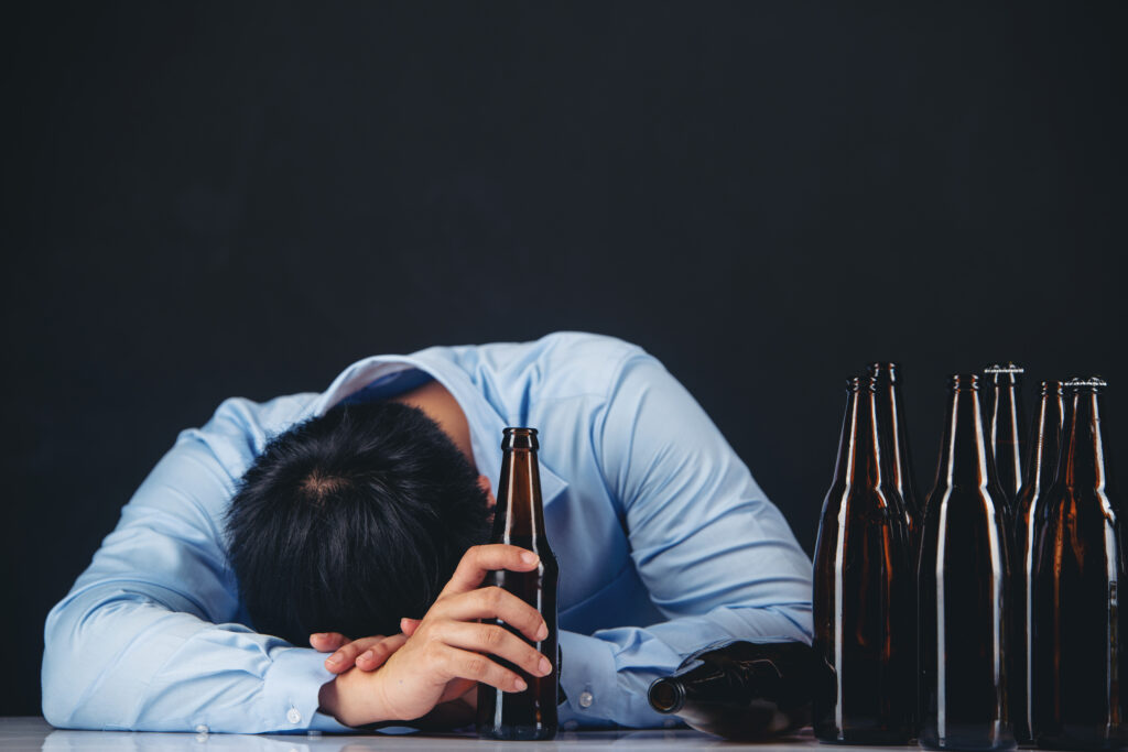 Man drinking alcohol, illustrating how excessive alcohol consumption can lower testosterone levels.