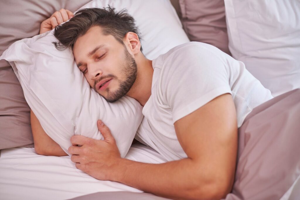 Man sleeping peacefully, emphasizing quality rest to naturally increase testosterone.
