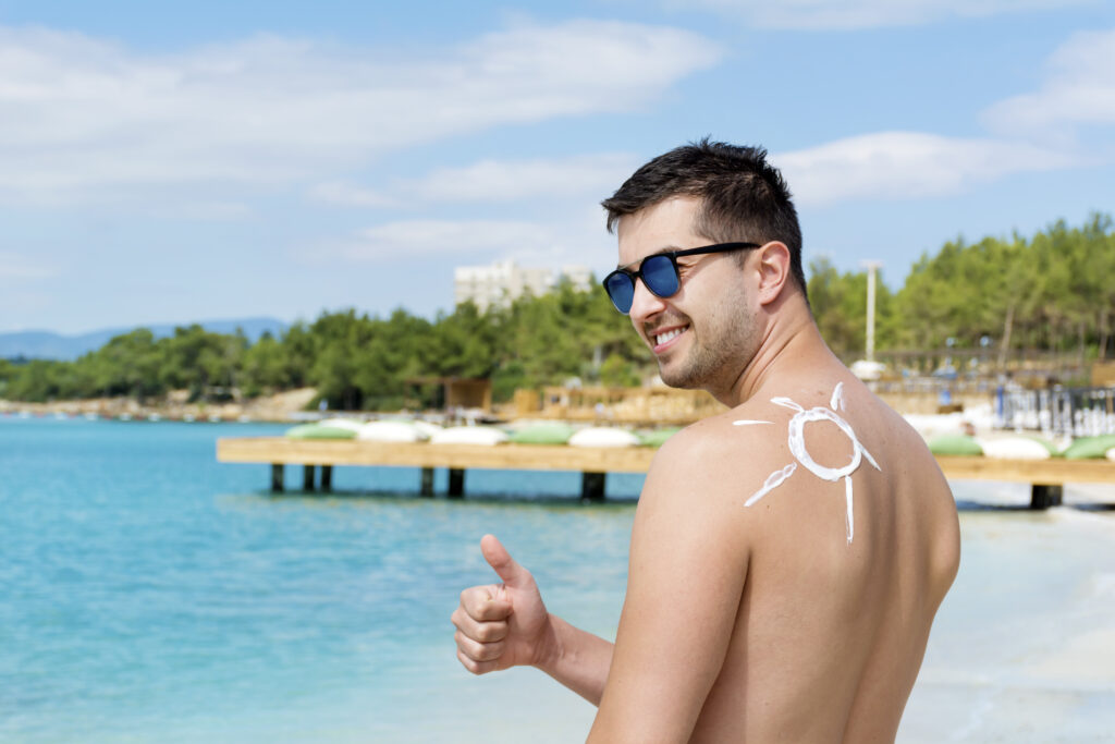 Man on the beach, sunbathing in order to achieve daily dose of Vitamin D