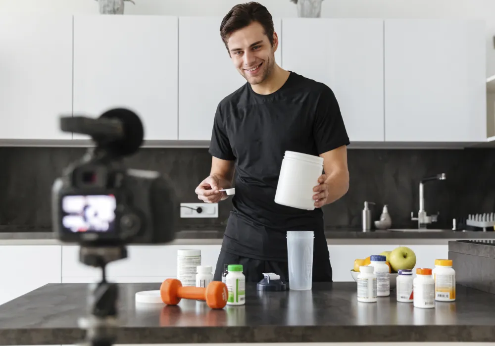 Happy young man mixing muscle-building supplements for his post-workout shake
