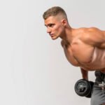 A fitness athlete doing dumbbell tricep kickback exercise