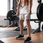 Young man training Romanian Deadlifts at the gym in Dubai.