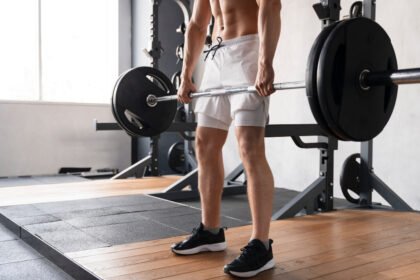 Young man training Romanian Deadlifts at the gym in Dubai.