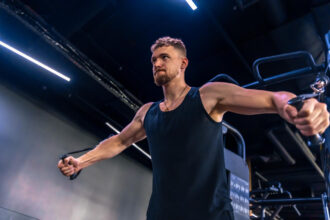 Fitness athlete doing Standing High to Low Cable Fly in a Dubai Gym