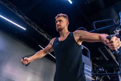 Fitness athlete doing Standing High to Low Cable Fly in a Dubai Gym