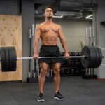 fit man doing straight legged deadlift indoors