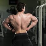 Bodybuilder showing his back muscle in the gym after a workout