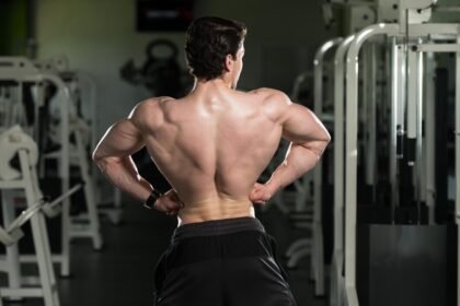 Bodybuilder showing his back muscle in the gym after a workout
