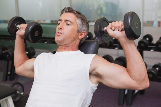 Mature man doing dumbbells shoulder military press in a gym in Dubai