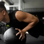 A man showing how to do a push-up on a medicine ball