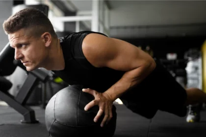 A man showing how to do a push-up on a medicine ball