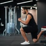 A young man doing bulgarian split squat exercise