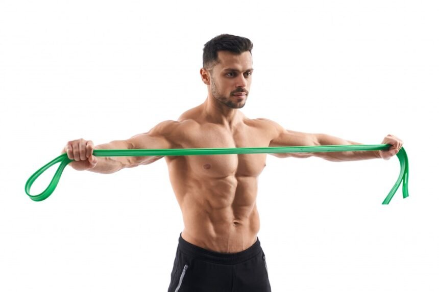 bodybuilder doing shrug exercise with resistance band.