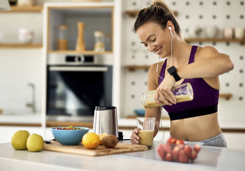 young happy athletic woman having protein smoothie