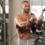 Fit man doing low to high cable flys chest workout