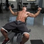 Fitness influencer demonstrating incline dumbbell flys exercise in Dubai
