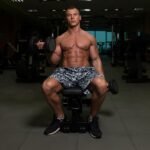 A fit Young man doing Incline Bench One Arm Bicep Curl