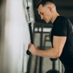 Young man demonstrating how to do a tricep extension