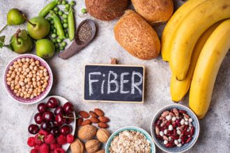 A colorful assortment of high-soluble fiber foods including oats, chia seeds, lentils, apples, bananas, and chickpeas, arranged on a rustic table.