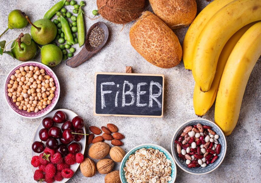 A colorful assortment of high-soluble fiber foods including oats, chia seeds, lentils, apples, bananas, and chickpeas, arranged on a rustic table.
