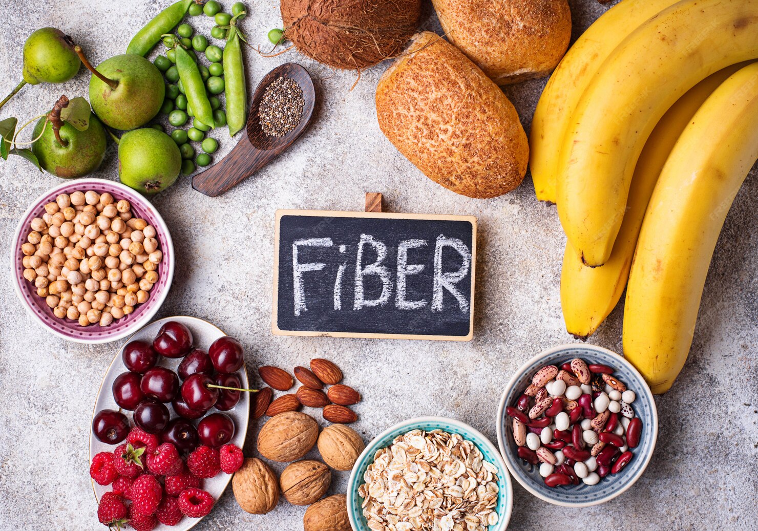 A colorful assortment of high-soluble fiber foods including oats, chia seeds, lentils, apples, bananas, and chickpeas, arranged on a rustic table.